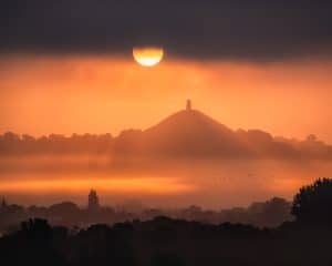 Fine art print of a Glastonbury Tor solstice sunrise with stormy skies