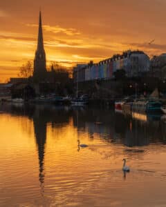 A fine art cityscape print of sunrise with swans at St Mary Redcliffe in Bristol